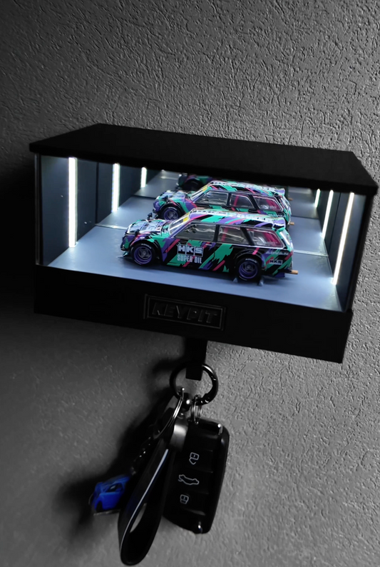 A wall-mounted lit display case holding a single 1:64 model car