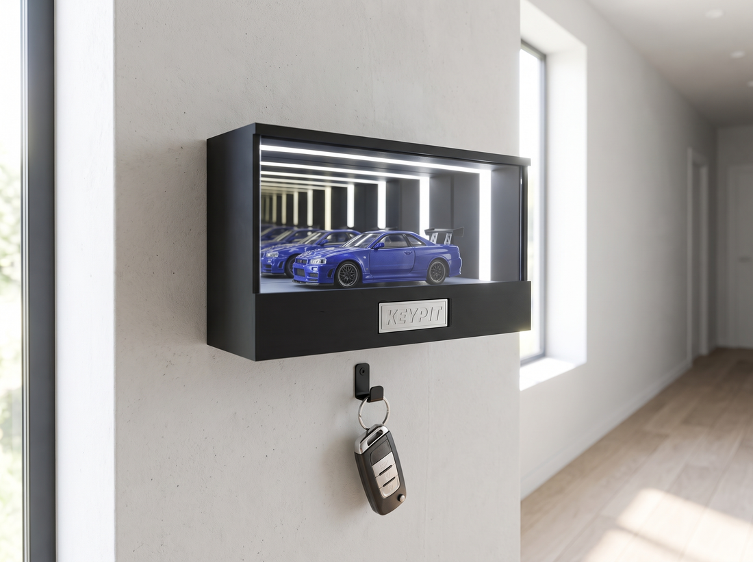 A wall-mounted lit display case in an entryway with a car key fob hanging on the hook underneath