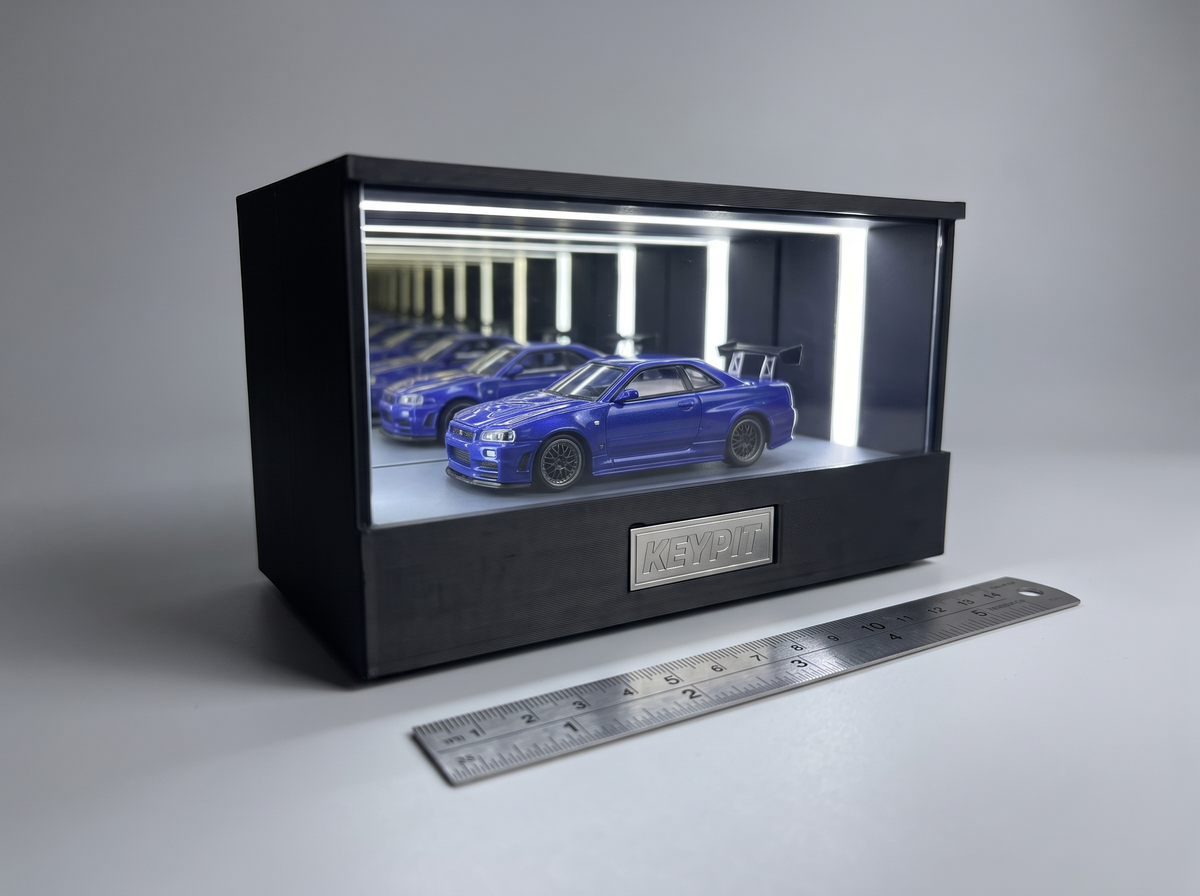A 1:64 diecast car in the lit KP Design Infinity Garage next to a metal ruler, showing how to check display fit