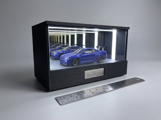A 1:64 diecast car in the lit KP Design Infinity Garage next to a metal ruler, showing how to check display fit