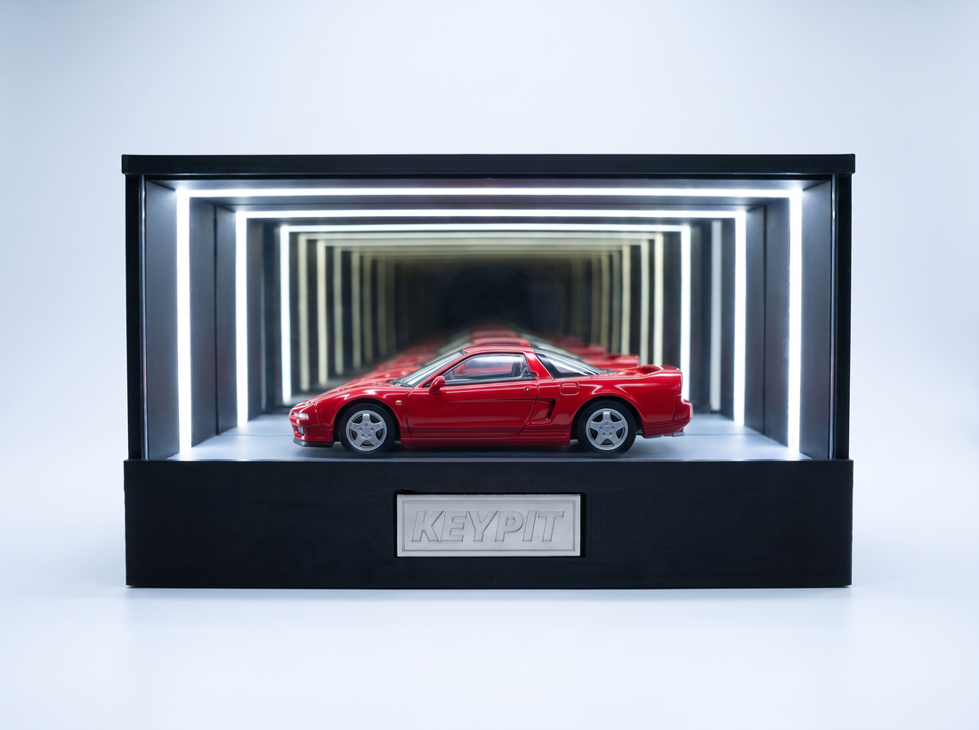 A red first-generation Honda NSX NA1 1:64 diecast displayed in the lit KP Design Infinity Garage case