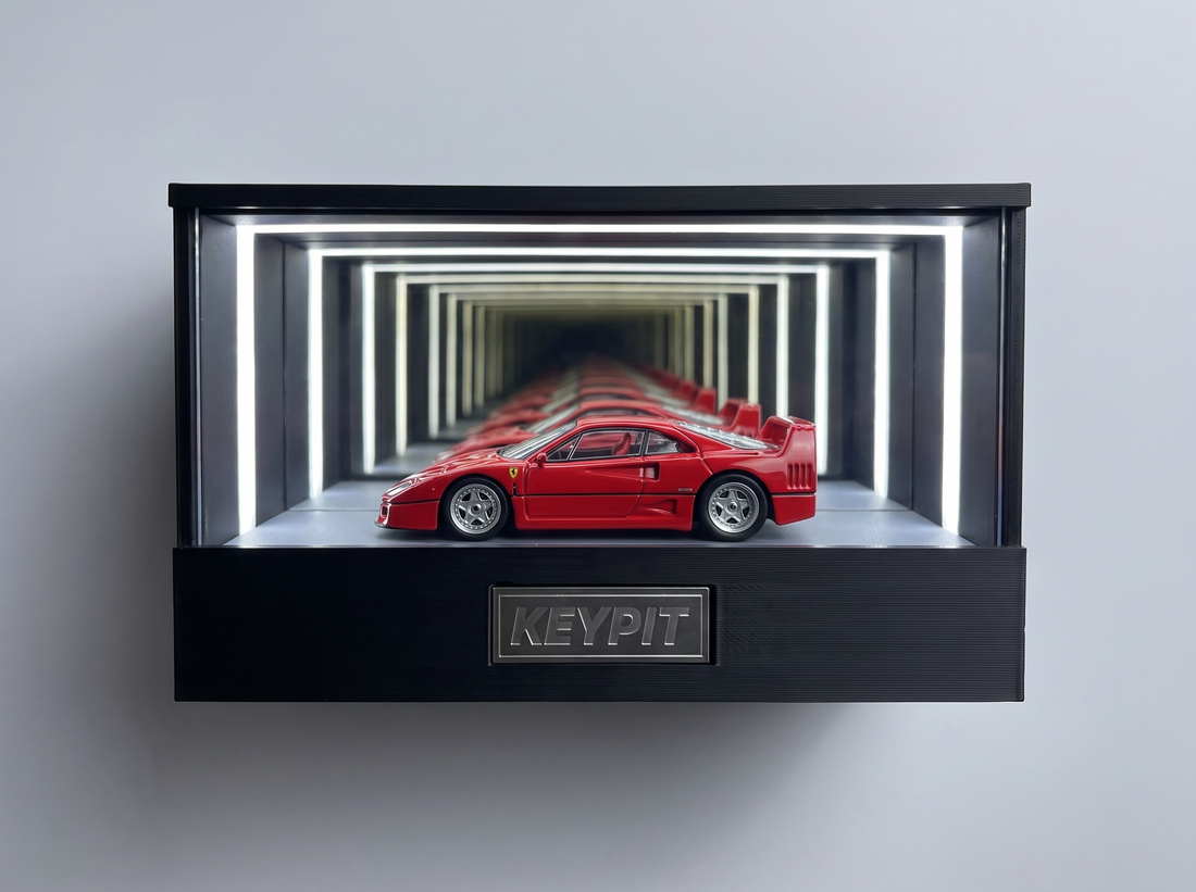 A red Ferrari F40 1:64 diecast with rear wing displayed in the lit KP Design Infinity Garage case