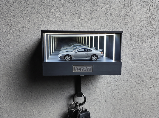 A silver 1:64 Nissan Silvia S15 shown in side profile inside a wall-mounted KP Design Infinity Garage display case