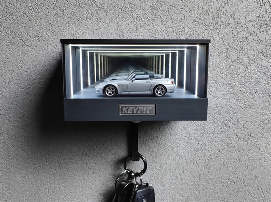 A silver 1:64 Honda S2000 shown in side profile inside a wall-mounted KP Design Infinity Garage display case