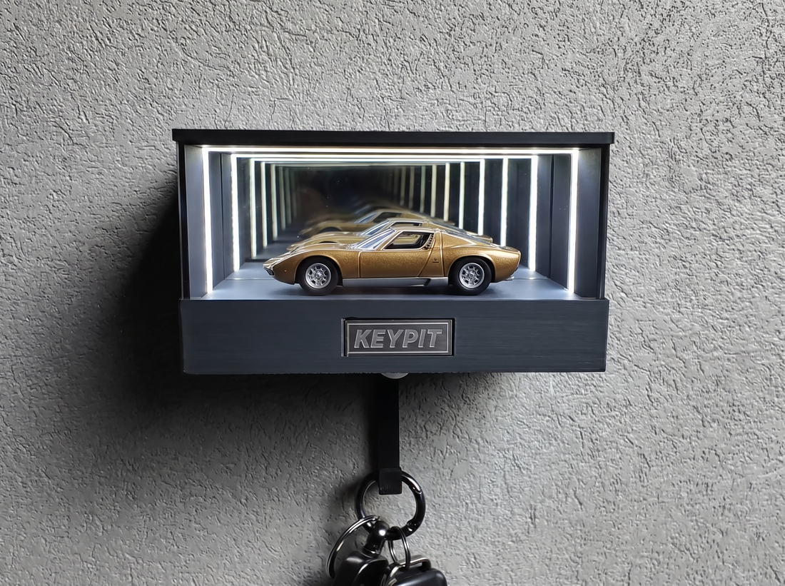 A gold classic supercar in 1:64 scale displayed in a lit infinity-mirror case