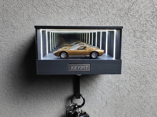 A gold classic supercar in 1:64 scale displayed in a lit infinity-mirror case