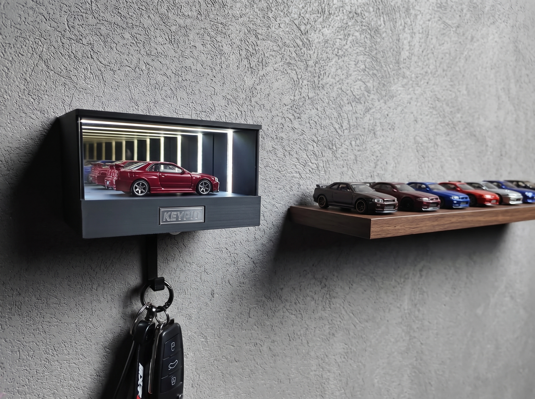 A single red 1:64 car lit in a wall-mounted display case beside a shelf holding a neat row of other diecast cars