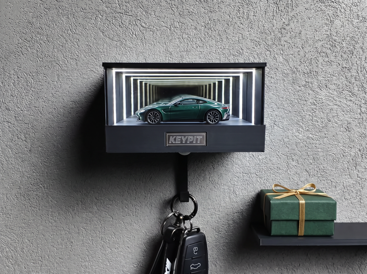 A green 1:64 sports coupe lit inside a wall-mounted display case, with a wrapped gift box on a shelf beside it