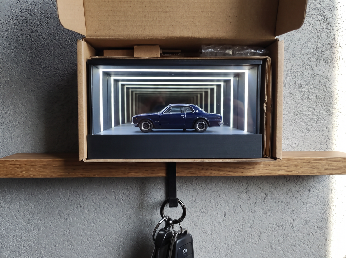 A display case half-unboxed from a plain kraft shipping box
