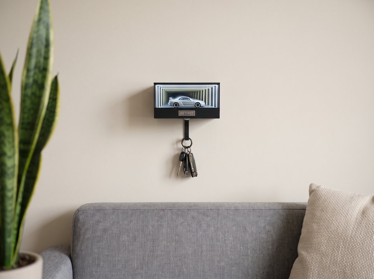 A lit wall-mounted display case holding one silver 1:64 car on a plain living-room wall above a grey sofa