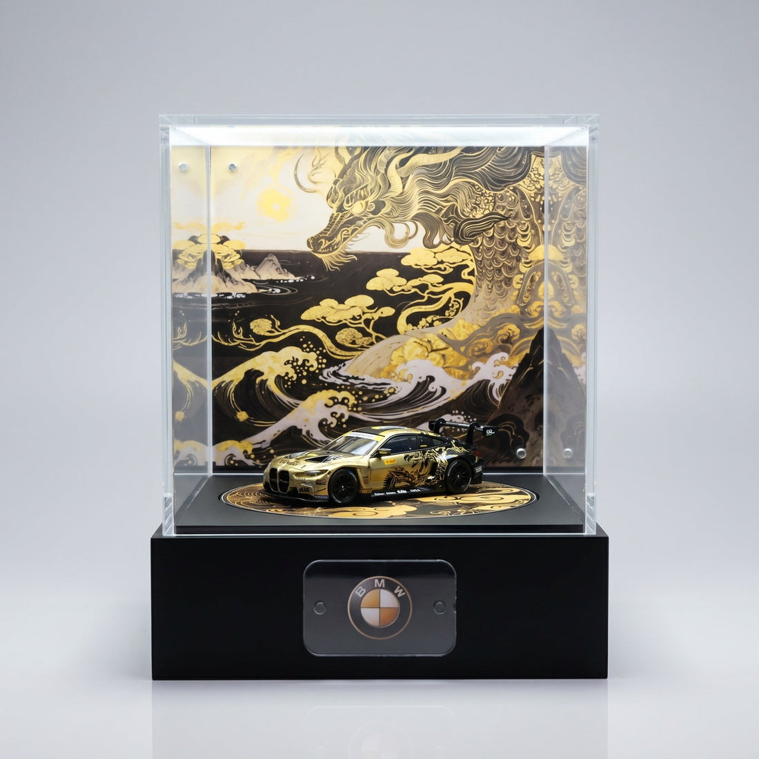 A gold and black BMW M4 GT 1:64 on a KP Design Rotating Stage with a plain BMW roundel nameplate on the base