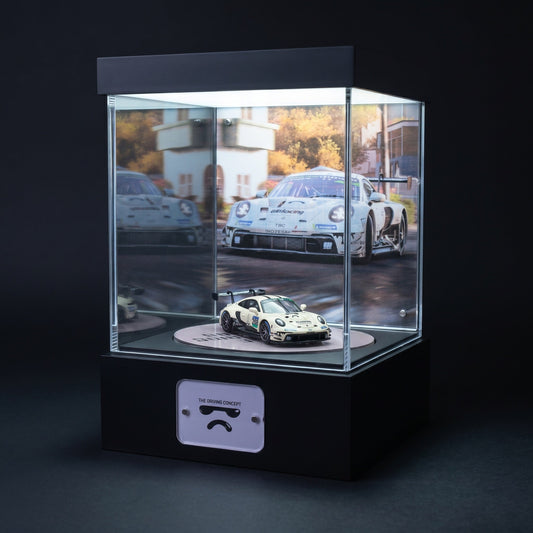 A white Porsche 911 GT3 R race car 1:64 in a lit KP Design Rotating Stage with a matching circuit backdrop and printed floor disc
