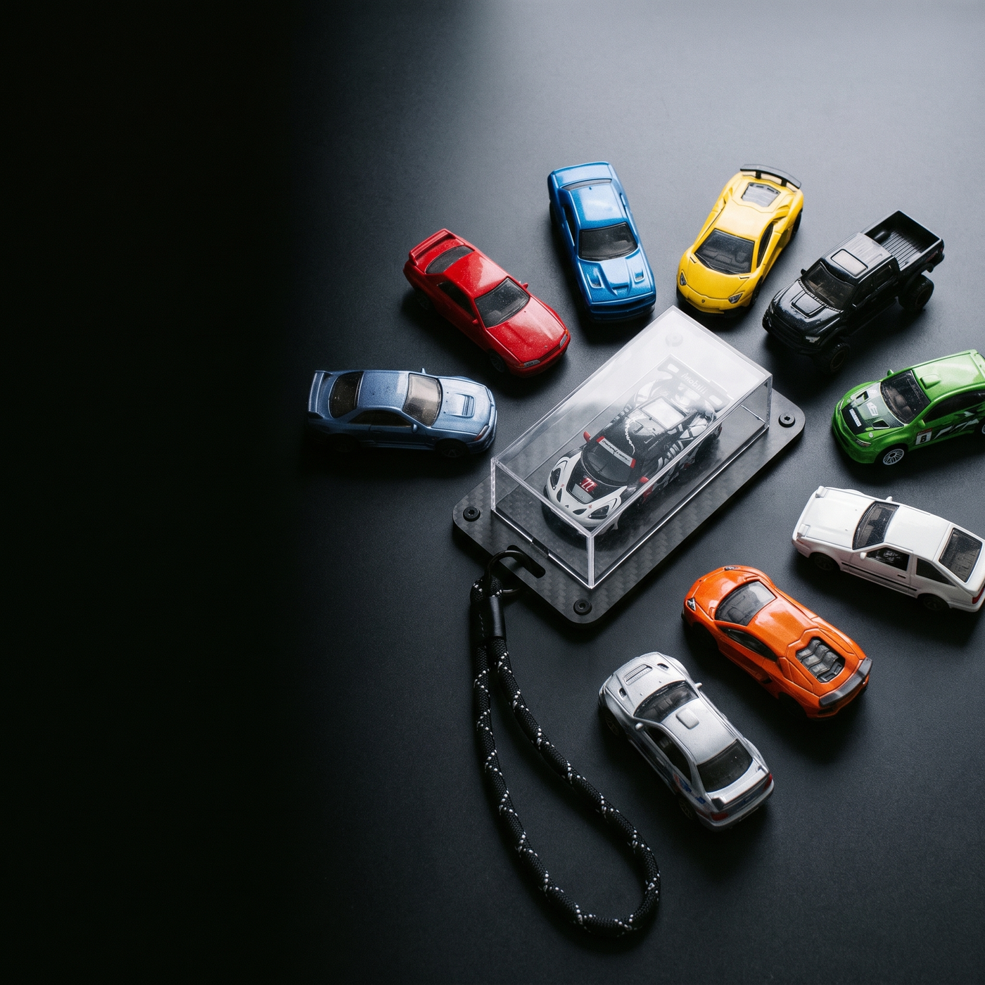A spread of 1:64 diecast cars beside the Pit Pass